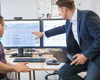 Jörg Kuchenmeister zeigt etwas auf einem Bildschirm