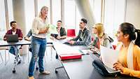 Klassenzimmer Reife Lehrerin und junge multi-ethnischen Studenten