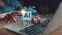 Nahaufnahme von Händen, die auf einer Laptop-Tastatur tippen, während über dem Bildschirm das Icon 'AI' schwebt.