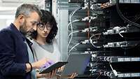 IT-Weiterbildung EIn Mann und eine Frau arbeiten an einem Server mit ihren Devices