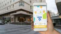 Handy mit Navigations-App vor Bürogebäude